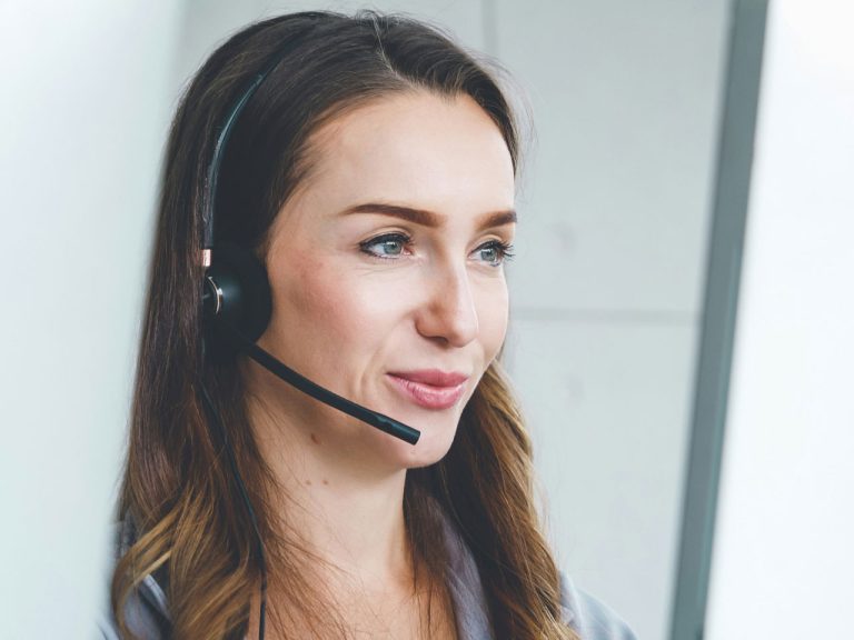 Freundliche Service-Mitarbeiterin mit Headset – kompetente Ansprechpartnerin für Fahrpläne, Tickets und die Mobilitätsgarantie von OWLmobil.